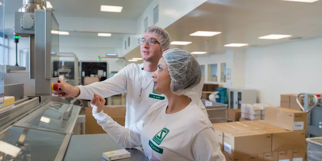 Ein Mann und Frau arbeiten an einer Konfektionierungslinie.