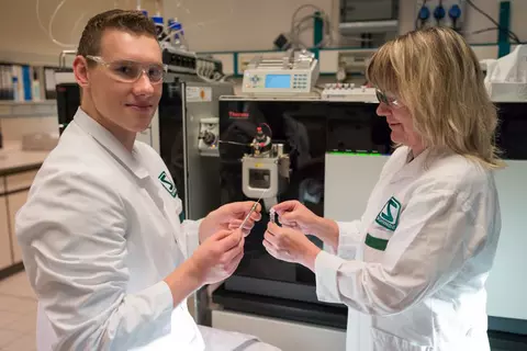 Zwei Mitarbeiter in Laborkittel und Schutzbrille im Labor
