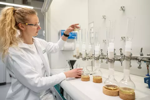 Eine Frau füllt eine Flüssigkeit in ein Reagenzglas