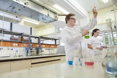 Ein Wissenschaftler füllt Flüssigkeit in ein Reagenzglas