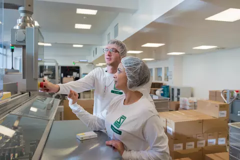 Ein Mann und Frau arbeiten an einer Konfektionierungslinie.